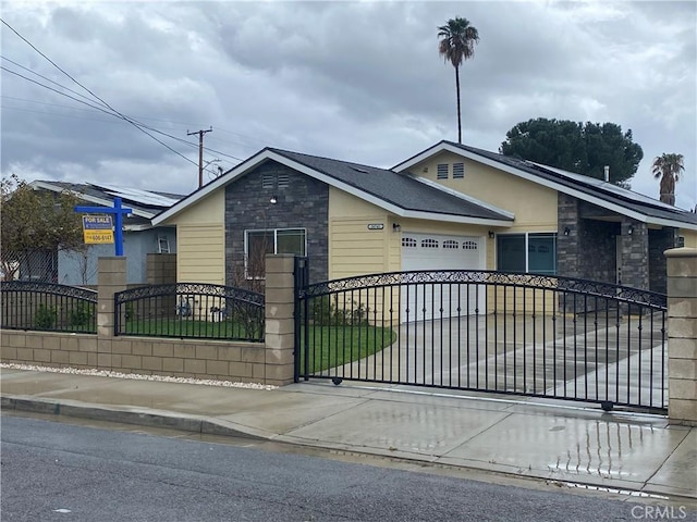 26741 Bruce St, Highland, CA 92346 - view of front of house with concrete driveway, an attached garage, stone siding, and a fenced front yard