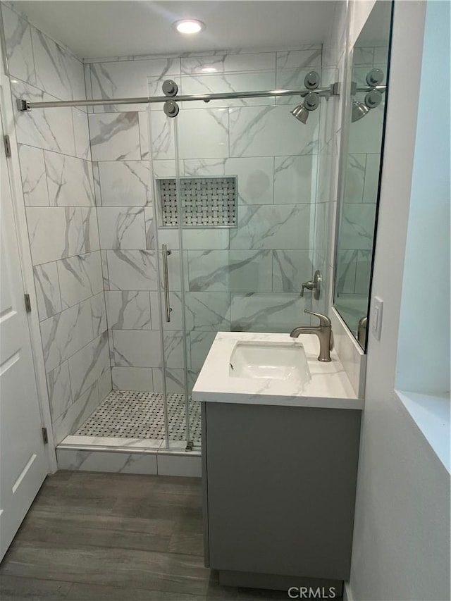 bathroom featuring vanity, a shower stall, and wood finished floors