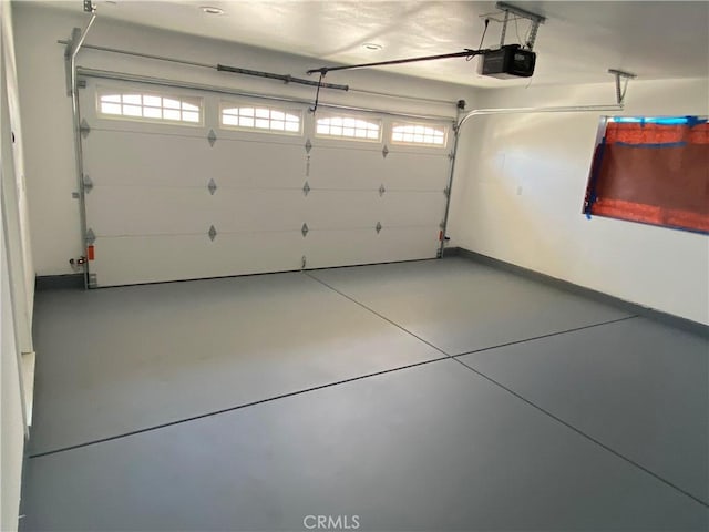 garage featuring a garage door opener and baseboards