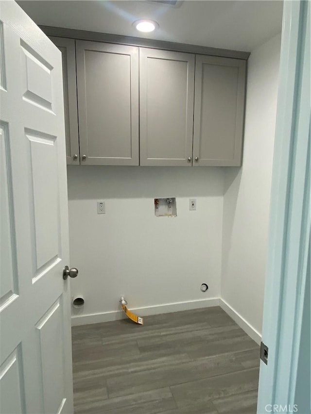 laundry room featuring baseboards, hookup for a washing machine, dark wood-style floors, cabinet space, and electric dryer hookup