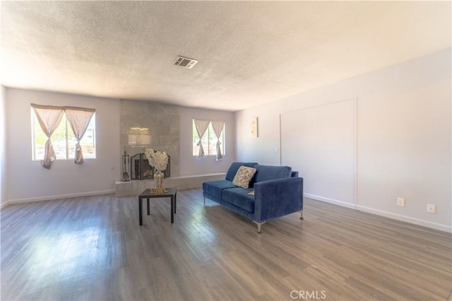 sitting room featuring a textured ceiling, wood finished floors, visible vents, and baseboards