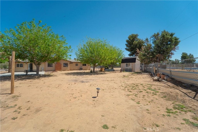 view of yard featuring fence, an outbuilding, and a storage shed