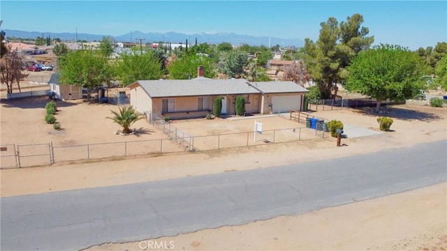 view of front of home featuring fence private yard, an attached garage, concrete driveway, and a mountain view