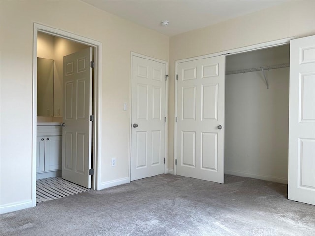 unfurnished bedroom featuring a closet, connected bathroom, baseboards, and carpet