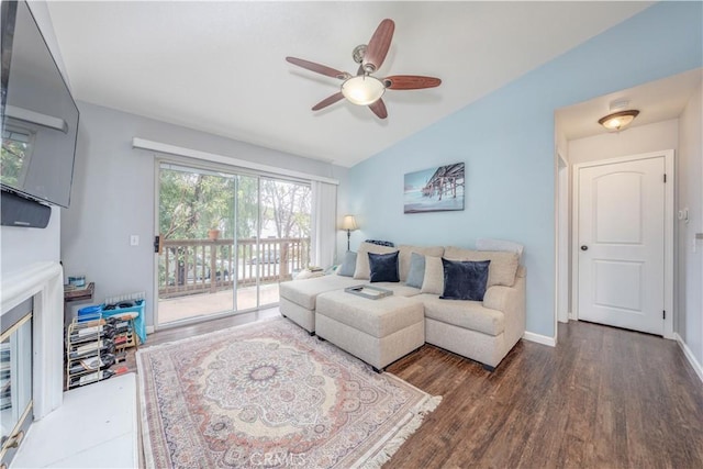 living area featuring baseboards, a ceiling fan, wood finished floors, and vaulted ceiling