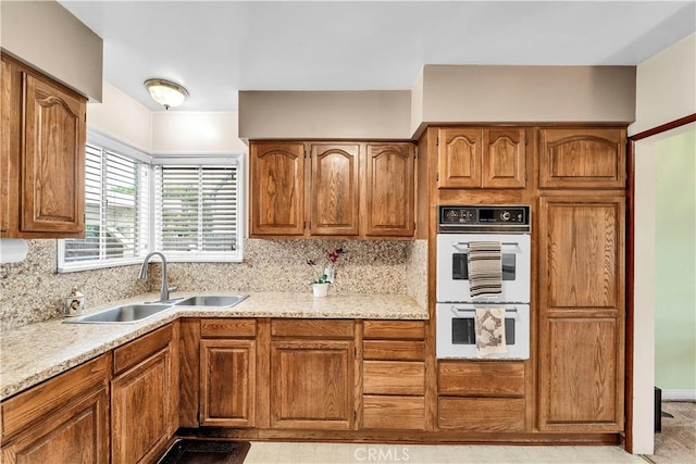 kitchen featuring brown cabinets, double oven, and a sink