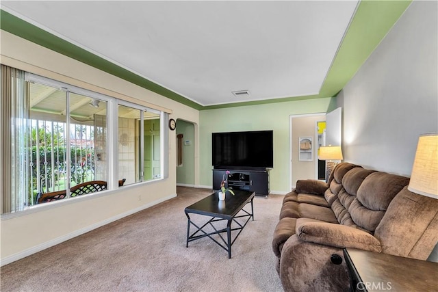 living area featuring visible vents, arched walkways, carpet floors, and baseboards