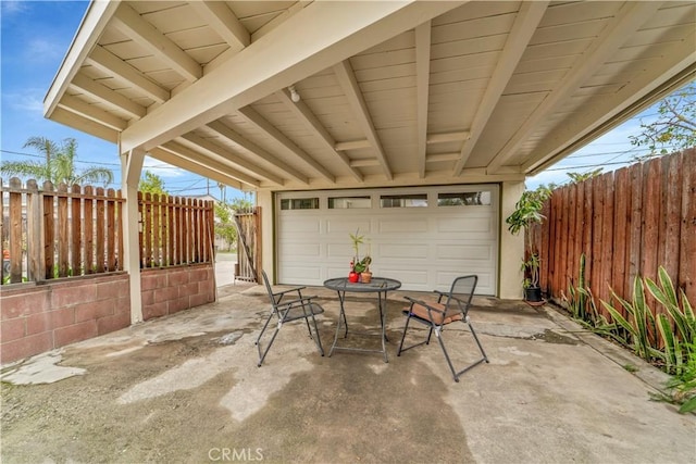 view of patio / terrace featuring a garage and fence