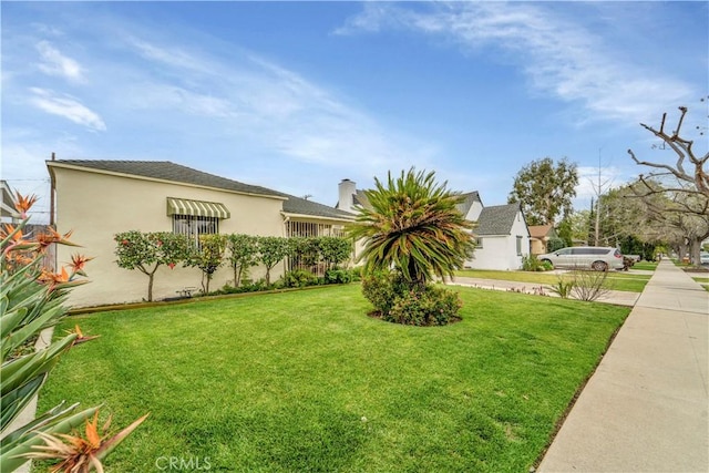 view of front of property featuring stucco siding and a front yard