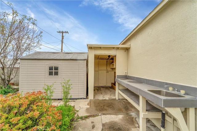 view of exterior entry featuring a sink and stucco siding