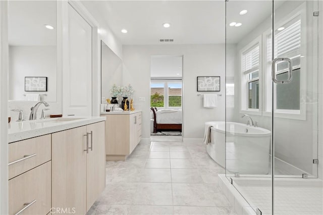 ensuite bathroom featuring vanity, a stall shower, visible vents, and a freestanding bath