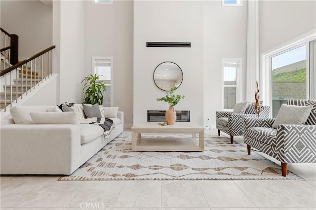 tiled living area featuring stairs and a high ceiling