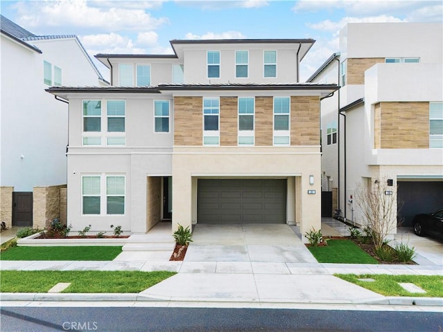 view of front of house featuring stucco siding, driveway, and a garage