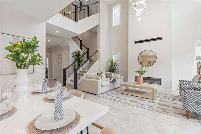 living room with stairs, recessed lighting, and a towering ceiling