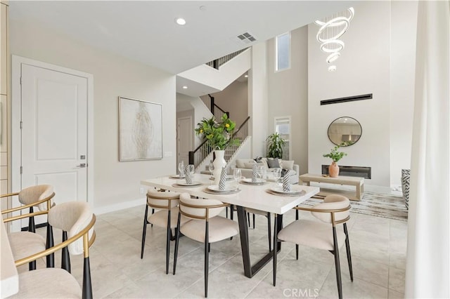 dining area with visible vents, recessed lighting, stairway, a high ceiling, and baseboards