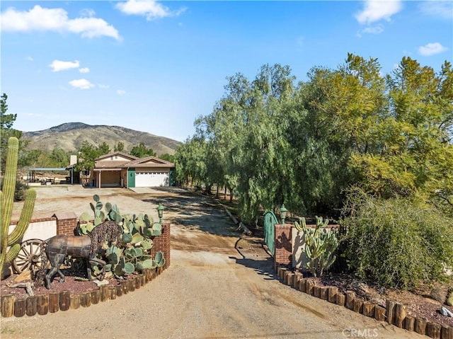 view of front of property featuring a garage, a mountain view, and driveway