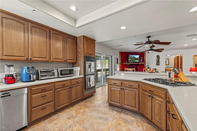 kitchen featuring a toaster, brown cabinets, and appliances with stainless steel finishes