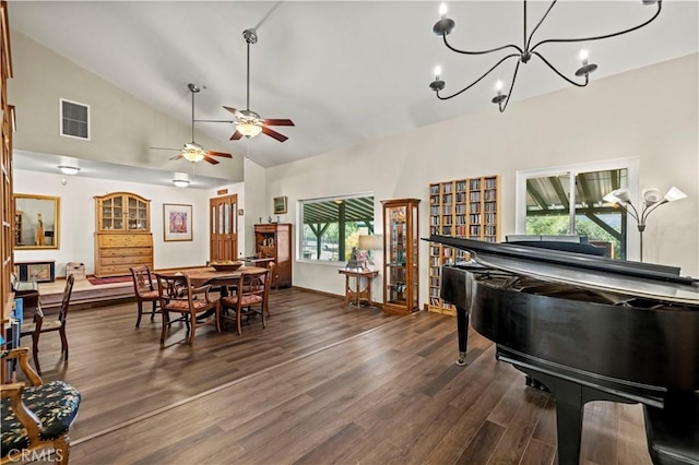 dining area featuring visible vents, dark wood-type flooring, ceiling fan with notable chandelier, baseboards, and lofted ceiling