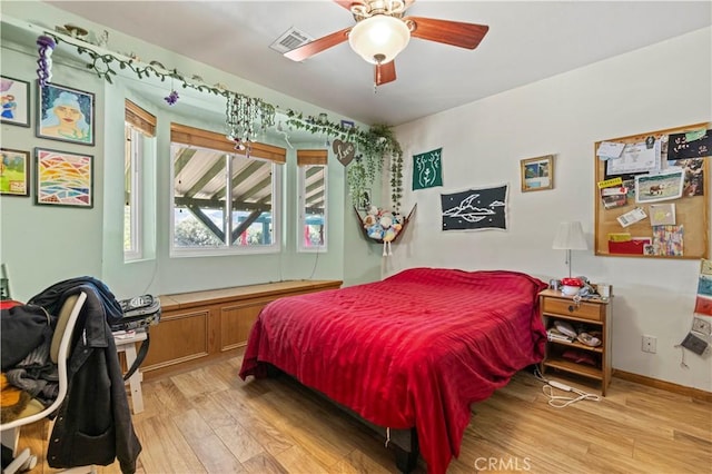 bedroom featuring visible vents, baseboards, light wood-style floors, and a ceiling fan