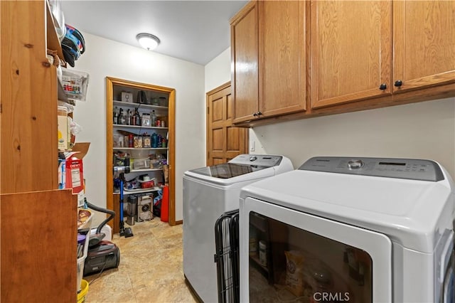 laundry room with washing machine and dryer and cabinet space