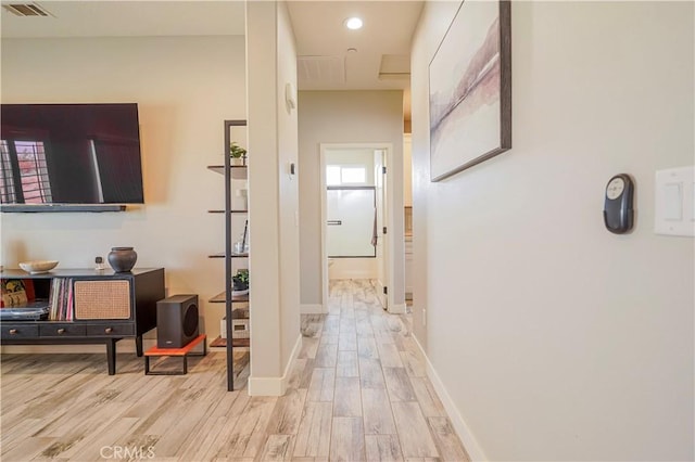 hall featuring light wood-type flooring, visible vents, baseboards, and recessed lighting