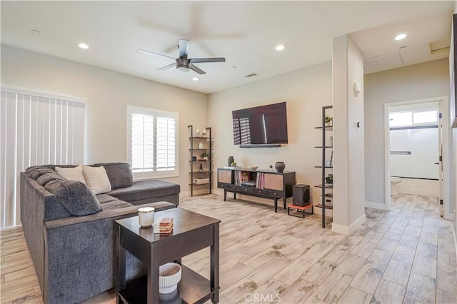 living area with light wood-style flooring, recessed lighting, a ceiling fan, and baseboards