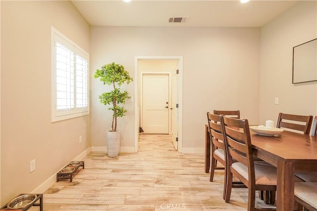 dining room with baseboards, visible vents, and light wood-type flooring