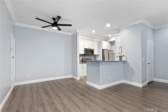 kitchen featuring ceiling fan, open floor plan, appliances with stainless steel finishes, wood finished floors, and white cabinetry