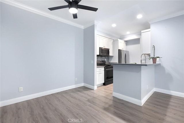 kitchen featuring decorative backsplash, baseboards, light wood-style floors, and appliances with stainless steel finishes