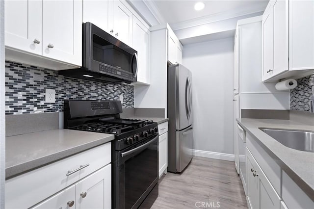 kitchen with tasteful backsplash, white cabinets, appliances with stainless steel finishes, and crown molding