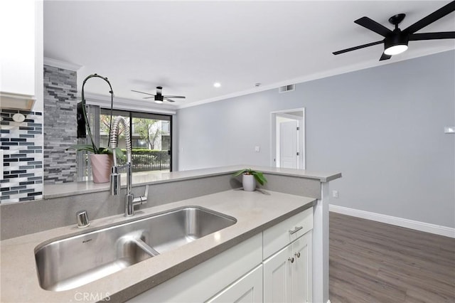 kitchen with white cabinetry, a ceiling fan, tasteful backsplash, and ornamental molding