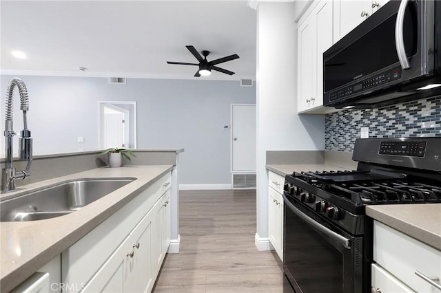 kitchen featuring visible vents, backsplash, gas range, a ceiling fan, and a sink