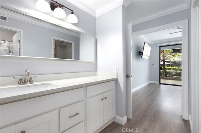 full bathroom with baseboards, vanity, wood finished floors, and crown molding