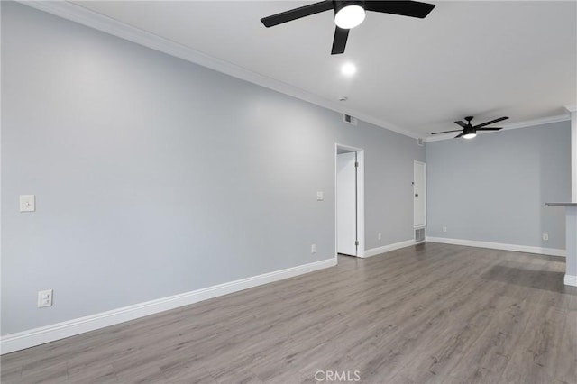 unfurnished room with visible vents, baseboards, ornamental molding, wood finished floors, and a ceiling fan