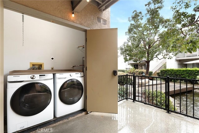 laundry area with laundry area, visible vents, and separate washer and dryer