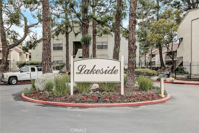 community sign featuring a residential view and fence