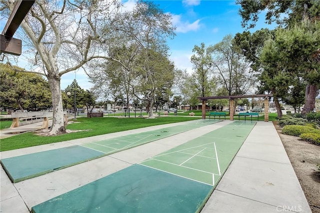 view of home's community featuring a lawn and shuffleboard