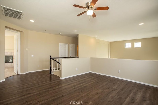 unfurnished room with recessed lighting, dark wood-style floors, visible vents, and baseboards