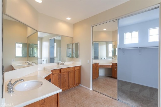 full bath featuring baseboards, two vanities, recessed lighting, a sink, and tile patterned flooring