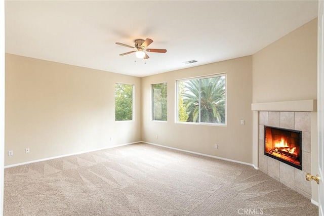 unfurnished living room featuring visible vents, carpet, a ceiling fan, and a tile fireplace