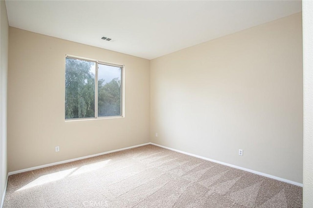 carpeted empty room with visible vents and baseboards