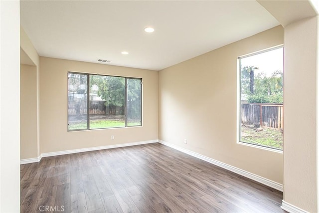 empty room featuring visible vents, recessed lighting, baseboards, and wood finished floors