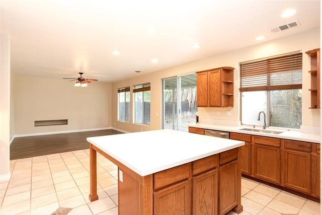 kitchen featuring brown cabinetry, visible vents, open shelves, a sink, and light countertops