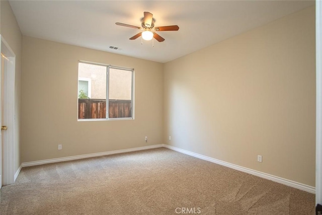 unfurnished room with visible vents, carpet floors, baseboards, and a ceiling fan