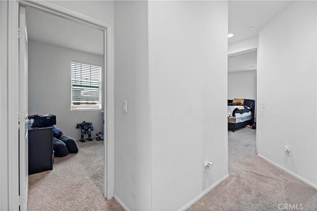 hallway with baseboards and carpet