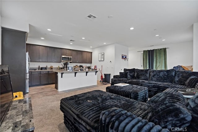 living area featuring recessed lighting and visible vents