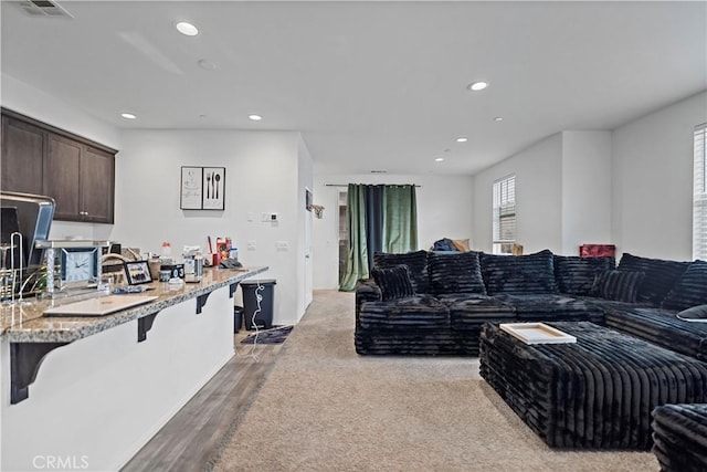 living room with wood finished floors, recessed lighting, and visible vents