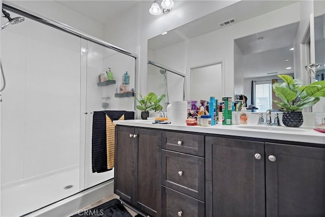 bathroom featuring vanity, visible vents, and a stall shower