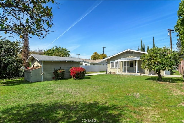 view of yard with an outdoor structure and fence