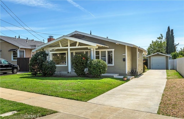 bungalow-style home with an outbuilding, a front lawn, driveway, fence, and a garage